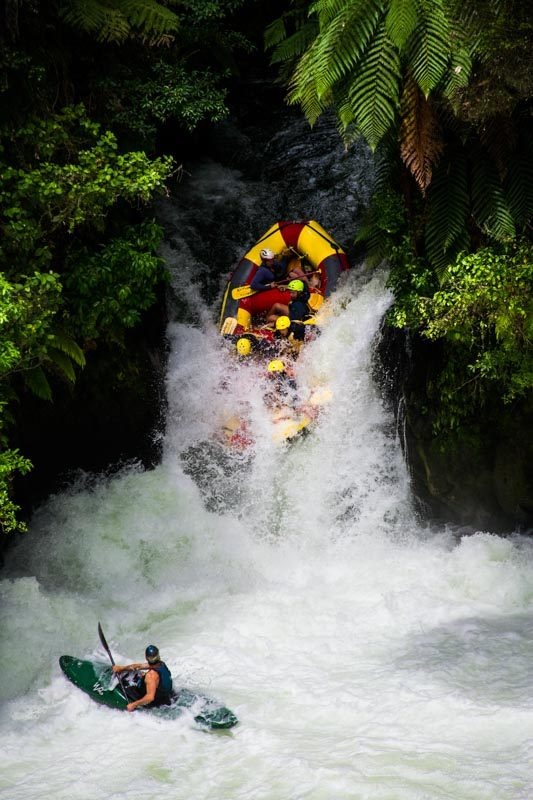 Zachranář pod vodopádem dohlíží na bezpečný průjezd přes Tutea Falls.