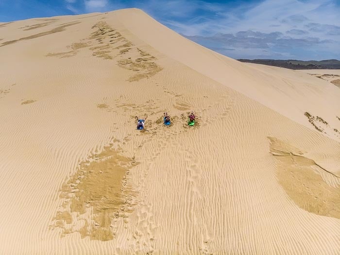 Písečné duny Te Paki na Novém Zélandu - Ukážeme vám nejlepší místo pro sandboarding i kde vypůjčit nejlevnější sand borady. Zažijte dobrodružství na dunách!