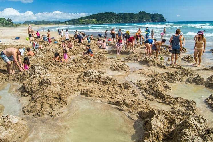A typical picture of Hot Water Beach - crowd of people around the hot spring.