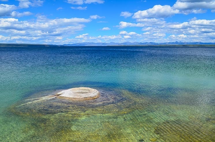 Yellowstone Lake is a lovely area. There is a Fishing Cone Geyser in the photo. 