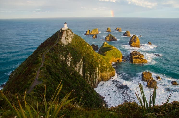 Západ slunce na Nugget Point Lighthouse, jižní ostrov, Nový Zéland