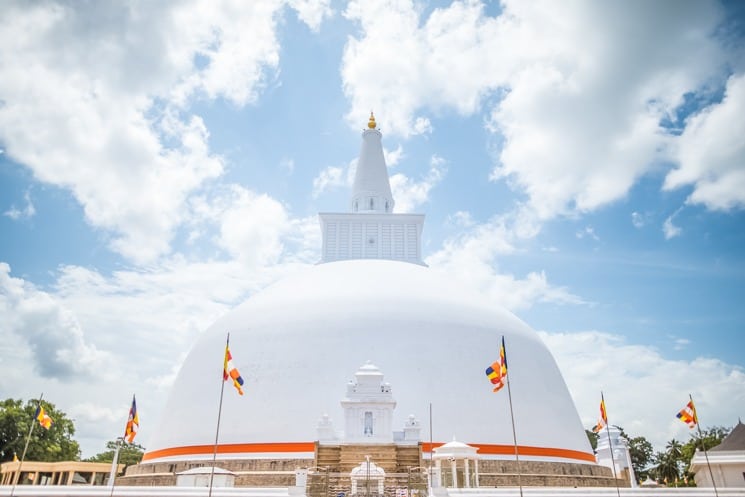  zděný plot okolo 2. největší stupy, Anuradhapura, buddhistické vlajky v pozadí , Srí Lanka